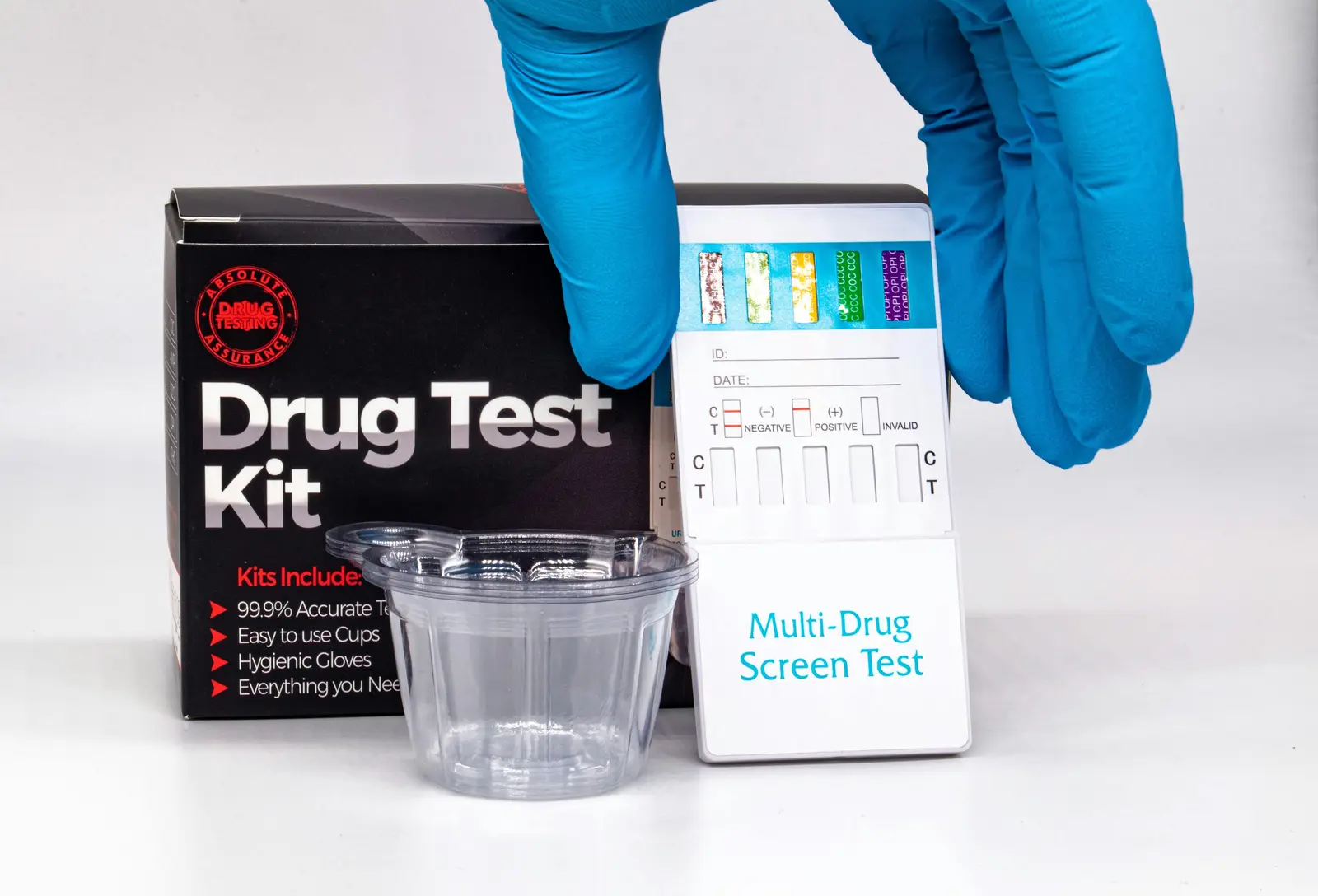 Does Suboxone Show Up on a Drug Test? A hand in a blue glove picking up a drug test kit.